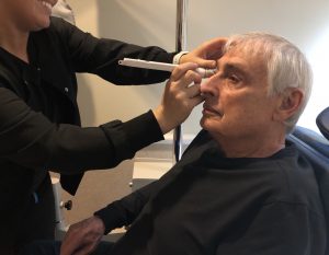 Senior man at eye doctor appointment, being checked for glaucoma and cataracts